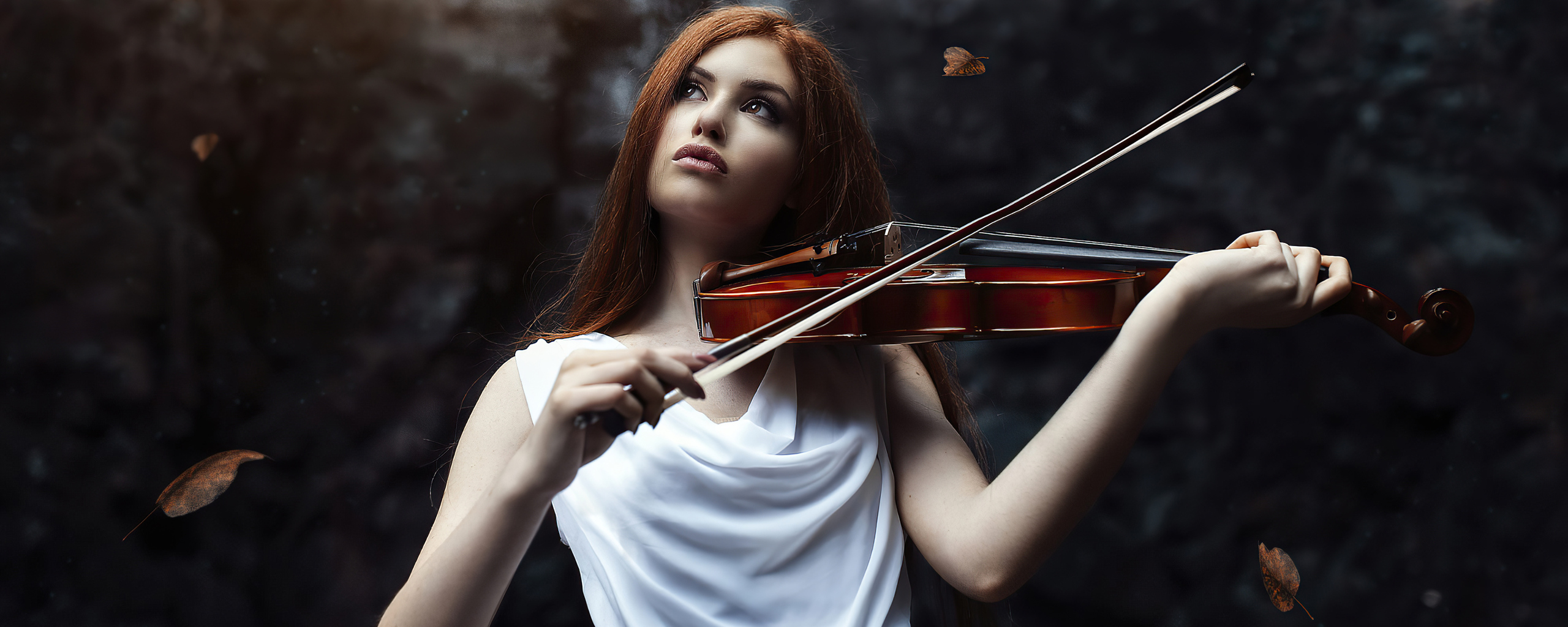 Талантливая девушка выступает фон. Девушка рыжая играет на скрипке черный фон.