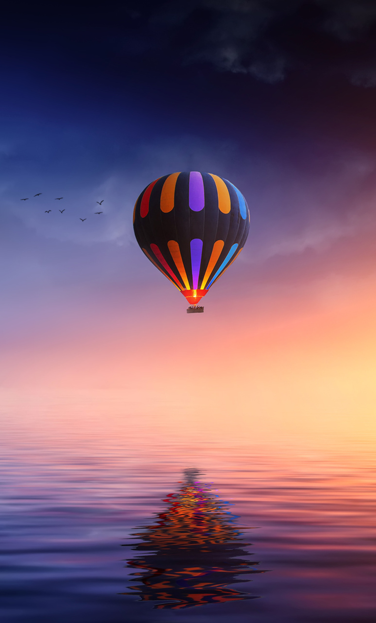 Red and Blue Hot Air Balloon Floating on Air on Body of Water during Night  Time  Free Stock Photo