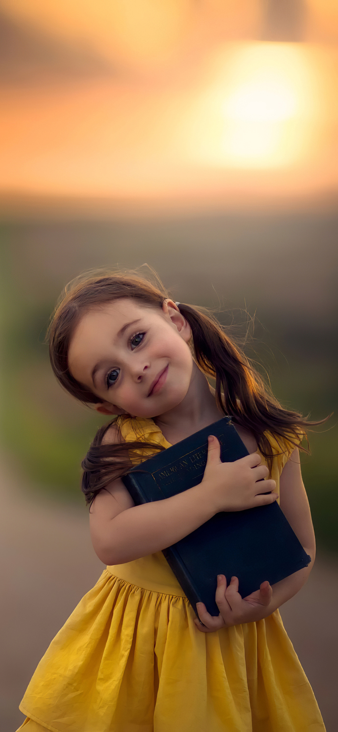 Little Cute Girl With Book Wallpaper In 1125x2436 Resolution