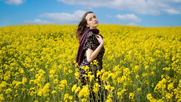 A Girl Amidst A Vibrant Field Of Sunflowers Wallpaper