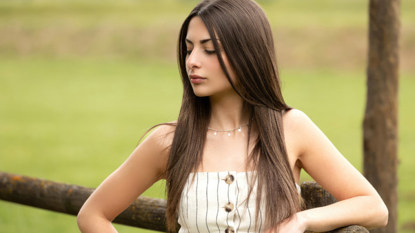 A Lovely Young Woman With Sleek Straight Hair Gazing Downward Wallpaper