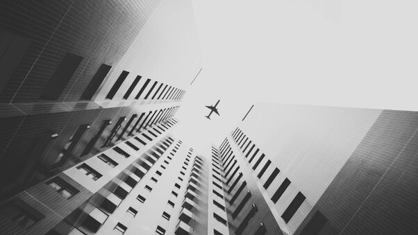 Airplane Flying Above Skyscrapers Wallpaper