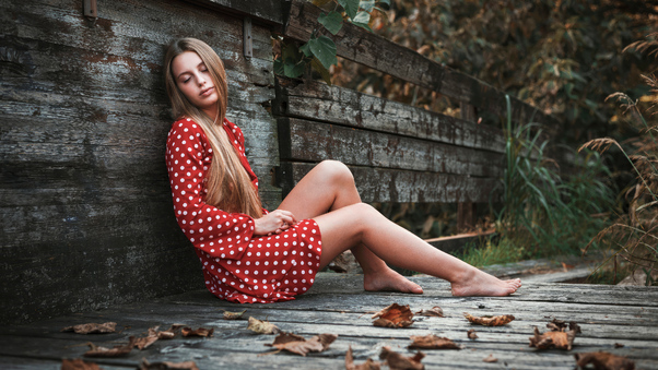 Beautiful Young Woman In Red Polka Dot Dress Sitting On Wooden Bridge Wallpaper