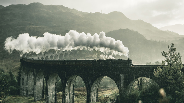 Black Train On Railway Bridge Under Heavy Clouds Wallpaper