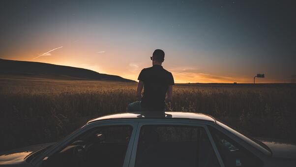 Boy Sitting On Top Of Car Watching Nature View 5k Wallpaper
