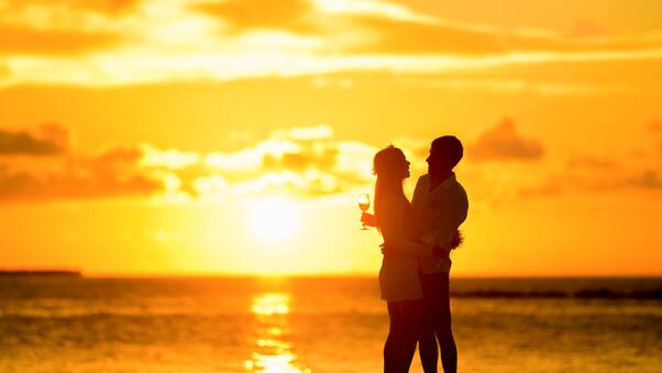Couple At Beach During Sunset Wallpaper