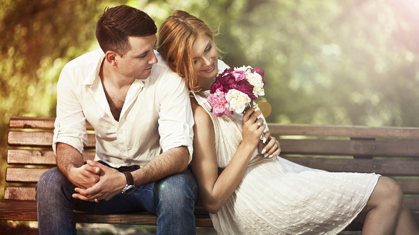 Couple Sitting On Bench With Flowers Wallpaper