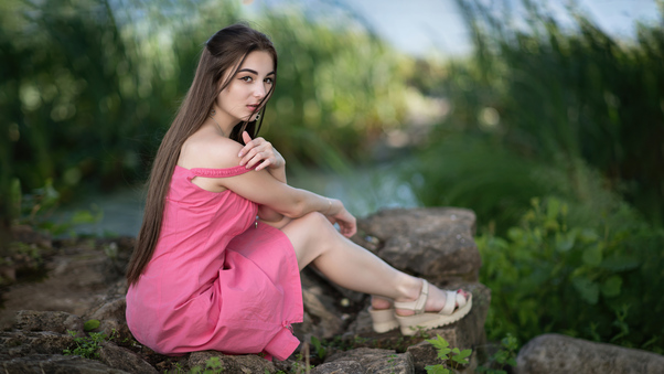 Cute Girl Sitting On Rock In Pink Dress Looking At Viewer 8k Wallpaper