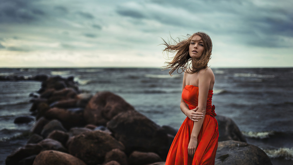 Girl In Orange Dress Wind Blowing At Beach Rocks 4k Wallpaper