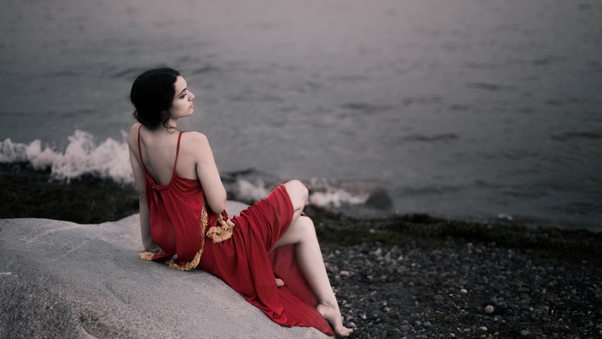Girl In Red Dress Sitting On Rocks Beach 8k Wallpaper