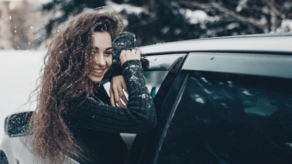 Girl In Snow Coming Out Of Car Window Wallpaper