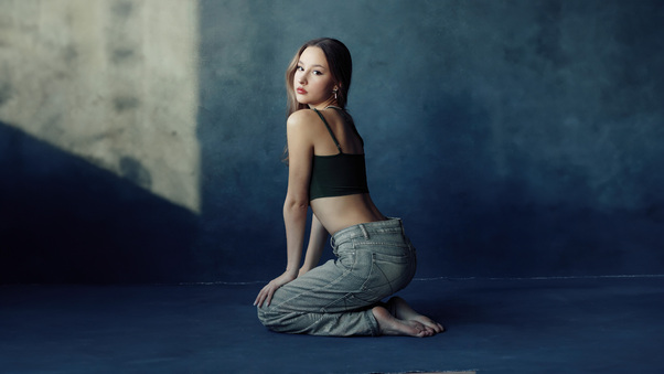 Girl Poses In Jeans Gazing Back Wallpaper