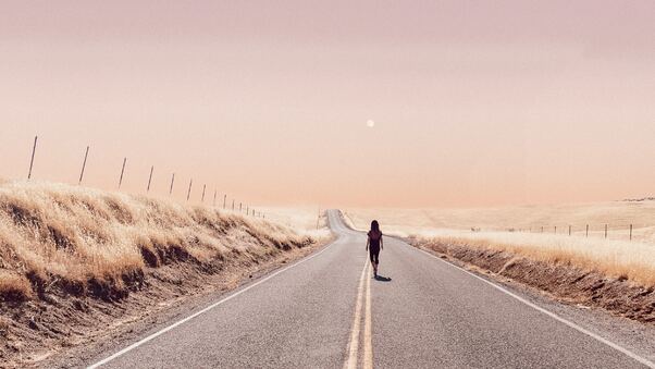 Girl Walking Alone On Desert Road Wallpaper