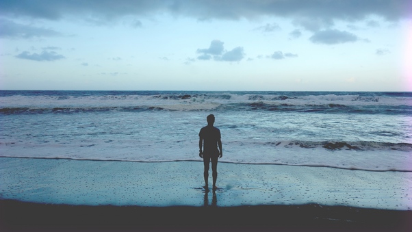 Man Standing At Ocean Shore Wallpaper