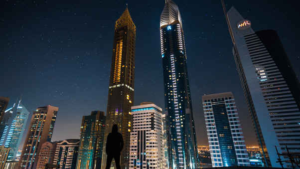 Man Standing Front Of Tall Buildings Wallpaper