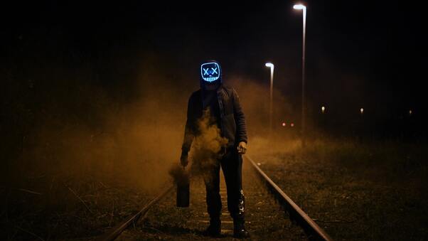 Mask Guy Walking On Railroad Wallpaper