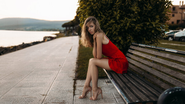 Model Sitting On Bench In Red Dress Wallpaper