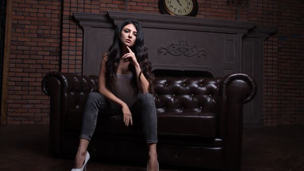 Model Sitting On Sofa Wearing High Heels Wallpaper