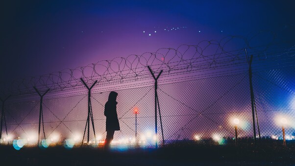 night-lights-person-standing-behind-fence-silhouetee-kc.jpg