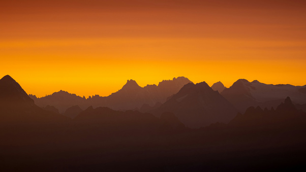 Sun Setting Over A Mountain Range Wallpaper