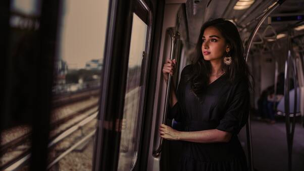 Women Standing In Train Holding Metal Rail While Looking Outside 5k Wallpaper