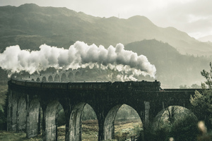 Black Train On Railway Bridge Under Heavy Clouds