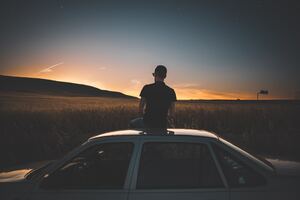 Boy Sitting On Top Of Car Watching Nature View 5k