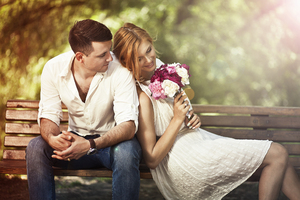 Couple Sitting On Bench With Flowers