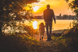 Father And Kid Walking Towards Lake