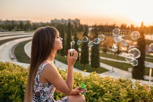 Girl Blowing Bubbles Outdoors