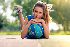 Girl Lying Down With Basketball In Ground