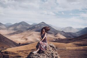 Girl Sitting On Rock Hairs In Air (1336x768) Resolution Wallpaper