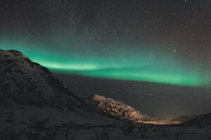 Northern Lights Over The Mountains Of Tromso (1360x768) Resolution Wallpaper
