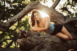 Smiling Girl Lying On Tree Branch Wallpaper