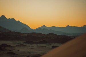 Sun Setting Over The Mountains In Desert (1600x900) Resolution Wallpaper