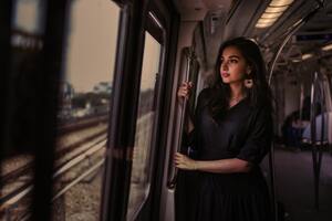 Women Standing In Train Holding Metal Rail While Looking Outside 5k (2560x1024) Resolution Wallpaper