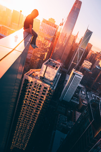 A Person Sitting On The Top Of A Tall Building (1080x2160) Resolution Wallpaper