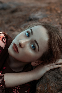 Blue Eyes Girl Lying On Beach Rock (750x1334) Resolution Wallpaper
