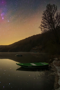 Boat Sitting On Top Of A Lake Under A Night Sky (1440x2560) Resolution Wallpaper