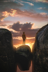 1080x2160 Boy Standing On A Boulder In Between Mountains