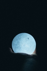 Close Up Photo Of Person Holding Moon Lamp (640x960) Resolution Wallpaper