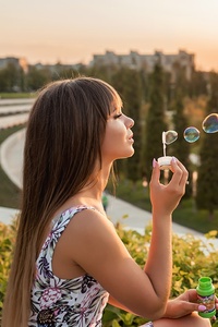 Girl Blowing Bubbles Outdoors (320x568) Resolution Wallpaper