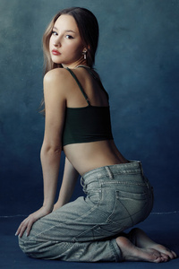 Girl Poses In Jeans Gazing Back (540x960) Resolution Wallpaper