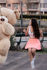 Girl With Big Teddy Bear On Swing