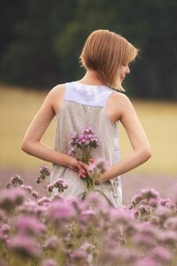 Girl With Flowers Standing In Field (640x1136) Resolution Wallpaper