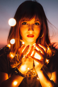 Light Glowing In Girls Hand 5k (640x1136) Resolution Wallpaper