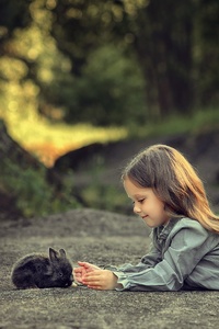 Little Girl Lying Down And Playing With Rabbit (240x320) Resolution Wallpaper