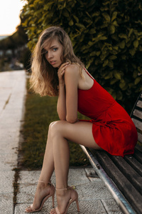Model Sitting On Bench In Red Dress (640x1136) Resolution Wallpaper