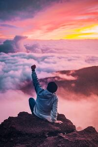 Person Sitting On Rock Looking At Sky (750x1334) Resolution Wallpaper