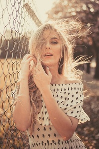 Woman Leaning On Chain Fence (320x568) Resolution Wallpaper